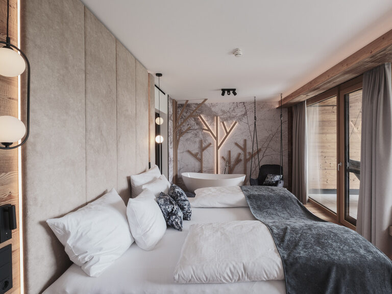 Gemütliches Schlafzimmer des Tonihof mit komfortablem Bett und weitem Fenster, das einen herrlichen Ausblick bietet.